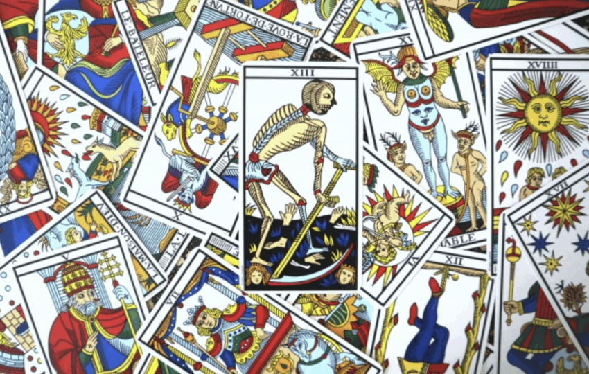 馬賽塔羅牌散落桌面，中央為死神牌，象徵結束與新生的精神轉化主題