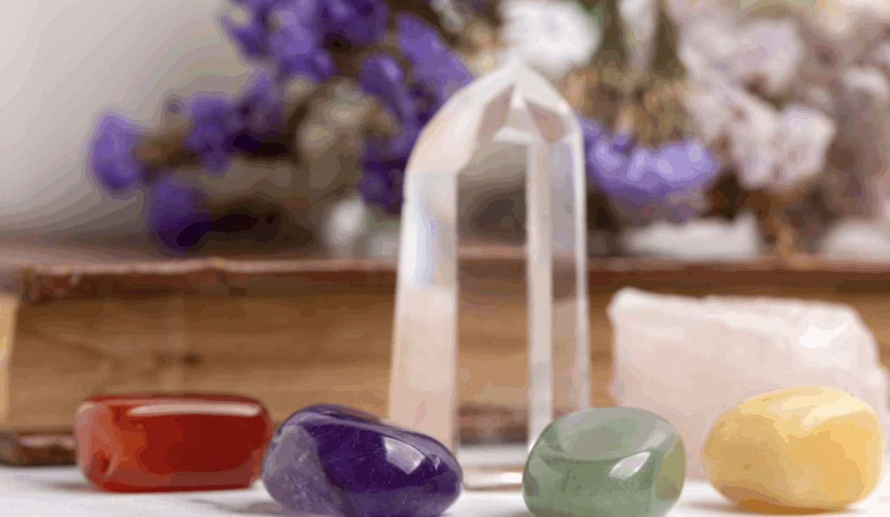 各色水晶和礦石排列/療癒水晶/紅瑪瑙紫水晶東陵玉黃玉與白水晶柱/能量石和花卉背景/心靈療癒與能量平衡