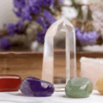 各色水晶和礦石排列/療癒水晶/紅瑪瑙紫水晶東陵玉黃玉與白水晶柱/能量石和花卉背景/心靈療癒與能量平衡