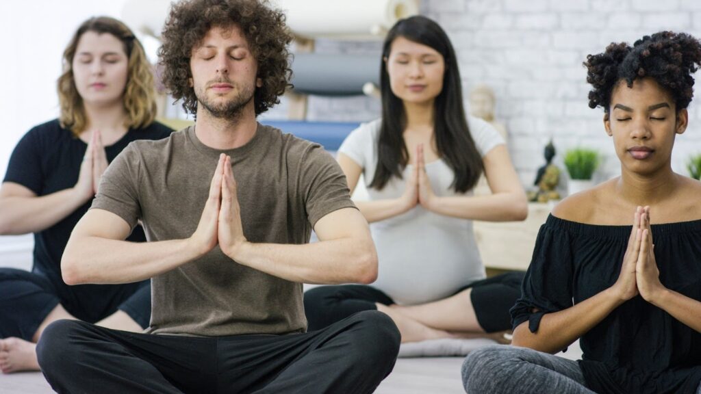 瑜伽靜心課程局部視角：學員在木地板上圍坐，前方擺放著用於音療放鬆的頌缽（Singing Bowl）