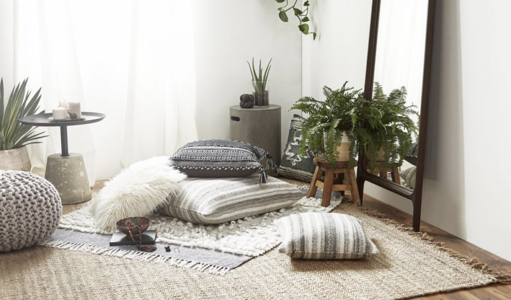 鋪有地毯與坐墊的簡約靜心角落，搭配綠色植栽與柔和採光，營造放鬆療癒的冥想空間