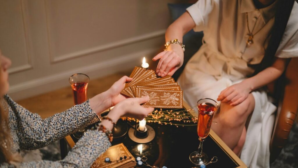 占卜師與個案互動細節，個案正從牌陣中挑選塔羅牌，氛圍溫暖靜謐