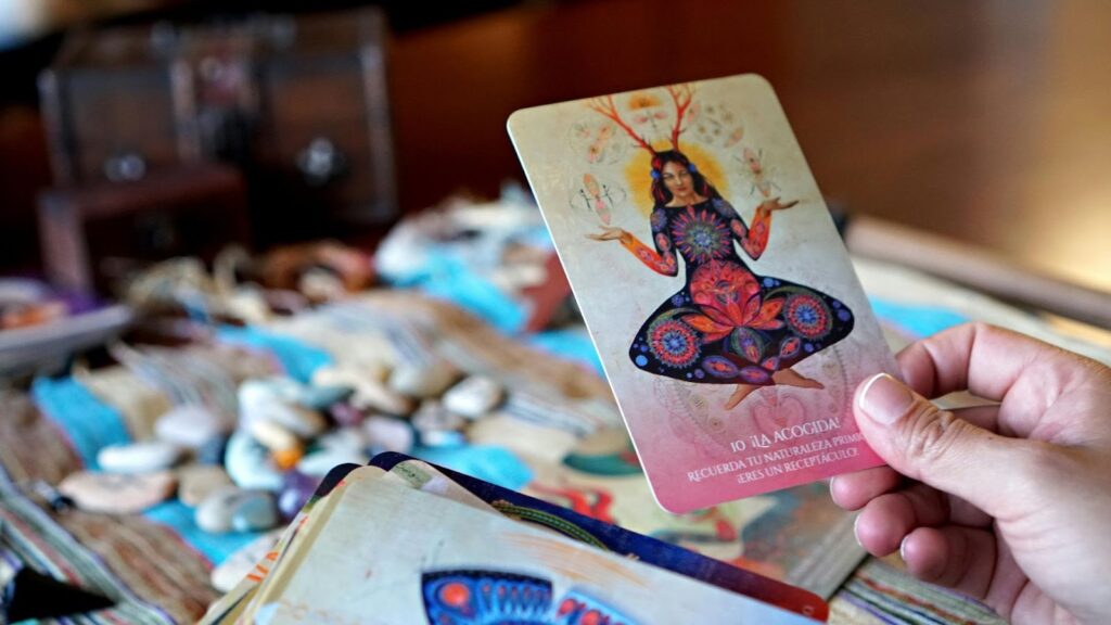 手持一張精緻的藝術神諭卡，背景為各種療癒礦石與占卜道具] 敘述： 每一張神諭卡都是一份宇宙的禮物，透過視覺藝術與直覺感應，為迷茫的靈魂提供溫柔的避風港與覺察方向。