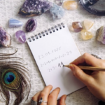 占卜師在擺滿紫水晶、孔雀羽毛與各類原礦的桌面上，正用鉛筆在筆記本上記錄生命靈數的計算過程，周圍環繞著充滿神祕學色彩的裝飾