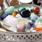 銀色托盤中擺放著各種色彩繽紛的拋光能量水晶原石，旁邊附有鼠尾草束與薰衣草。